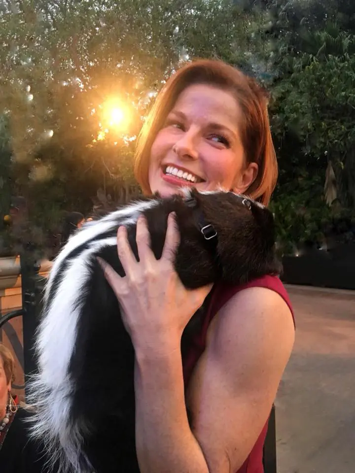 A woman holding an animal in her arms.