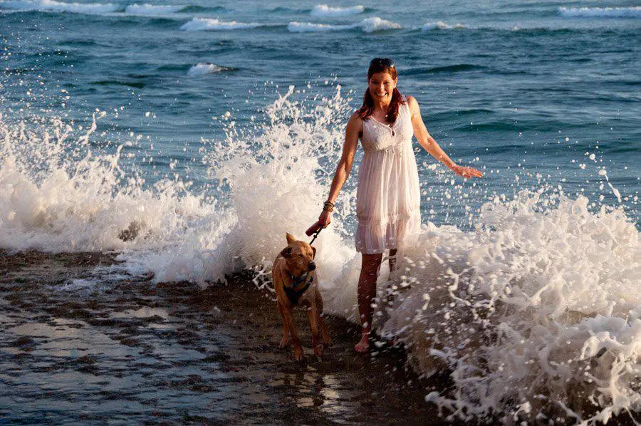 A woman and her dog are in the water.